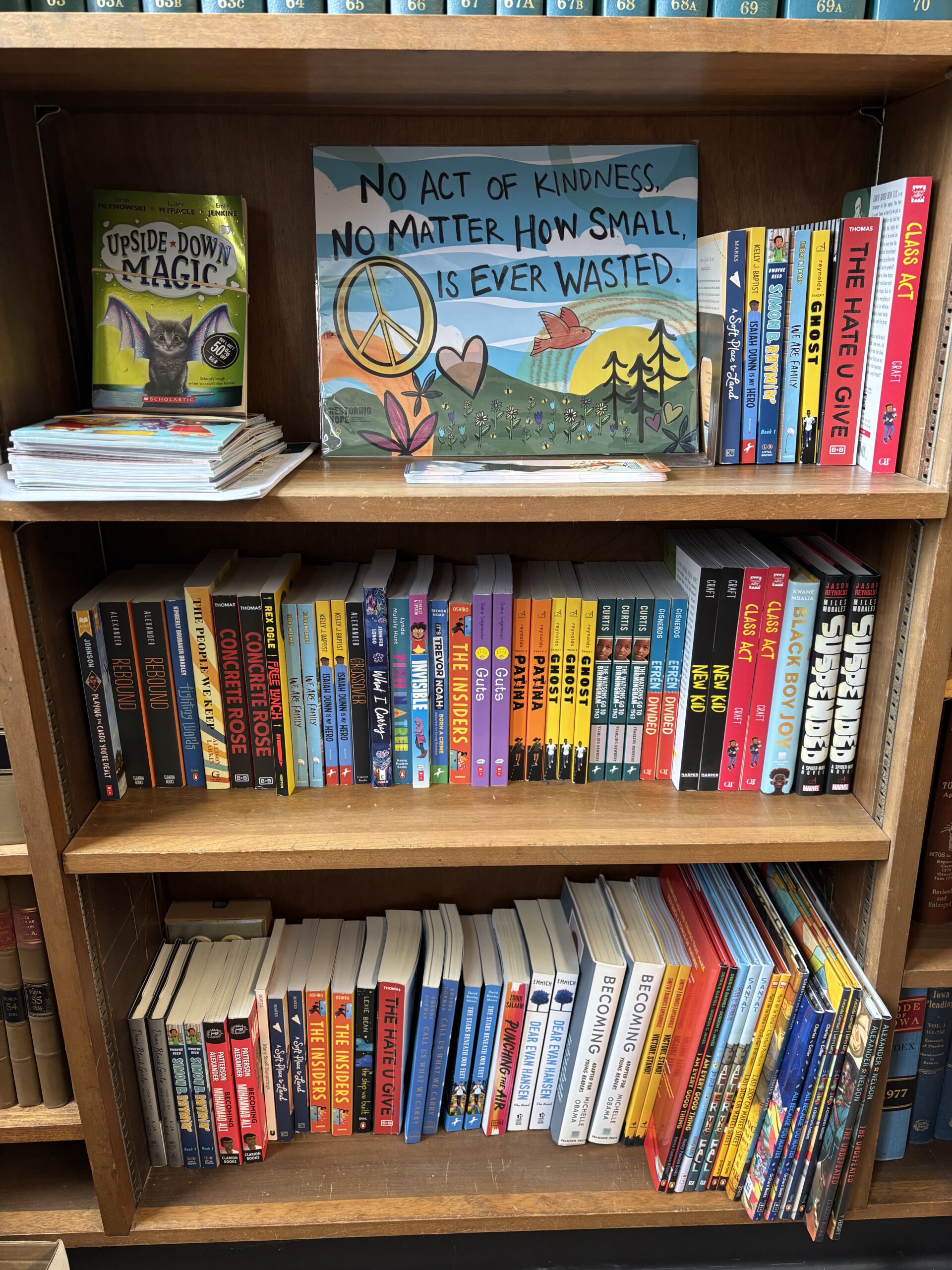 Bookshelf with a hand-painted no act of kindness is ever wasted sign